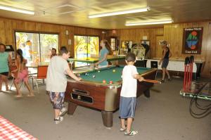 a group of people playing pool in a room at Gateway to Cape Cod Vacation Cottage 1 in Rochester