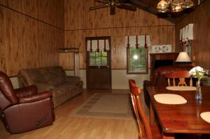 een woonkamer met een bank en een tafel bij Carolina Landing Camping Resort Luxury Cabin 8 in Fair Play