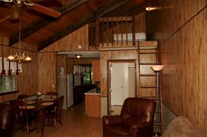 sala de estar con mesa y sillas y cocina en Carolina Landing Camping Resort Luxury Cabin 8, en Fair Play