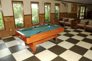 - une table de billard assise sur un sol en damier dans l'établissement Carolina Landing Camping Resort Luxury Cabin 8, à Fair Play
