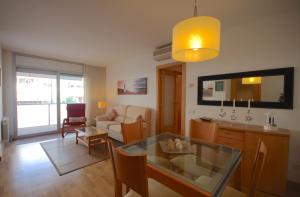 a living room with a glass table and a couch at Lets Holidays Cozy Pool Apartment in Tossa de Mar