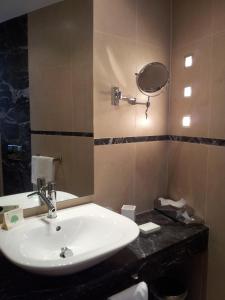 a bathroom with a sink, mirror, and bathtub at Excelsior in La Maddalena