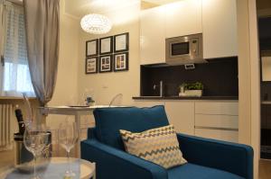 ein Wohnzimmer mit einem blauen Stuhl und einem Tisch in der Unterkunft Parma City Centre Holiday House in Parma