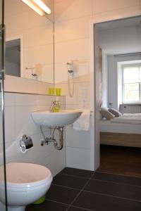 a bathroom with a sink and a toilet at Winkelwerkstatt Hotel in Kröv