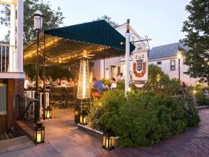 a patio with people sitting at a restaurant under a canopy at Jared Coffin House in Nantucket