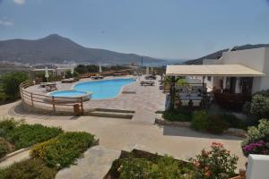a resort with a swimming pool and mountains in the background at Amorgion Hotel in Katapola