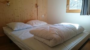 a bed with two pillows on it in a room at camping du haut des bluches in La Bresse