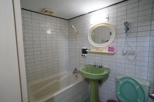 bagno con lavandino verde e vasca di Yi Yuan Hotel a Taipei