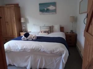 a bedroom with a bed with stuffed animals on it at AnchorageWells Entire Cottage OR a King Ensuite on Room Only in Wells next the Sea