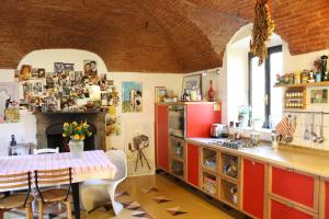 a kitchen with a table and a fireplace in it at Otium B&B in Cavallirio
