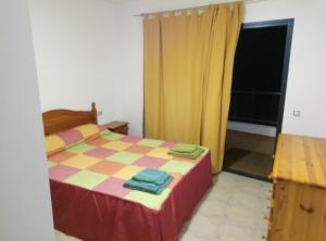 Puerto de las LajasにあるAPARTAMENTO PRIMERA LÍNEA DE PLAYAのベッドルーム1室(チェッカー付きのベッド1台付)