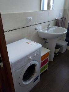 パレルモにあるCasa vacanza Pupiddaのバスルーム(洗濯機、シンク付)