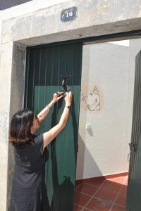 een vrouw die een foto neemt van een groene deur bij 16 Porto Santo Apartments in Porto Santo