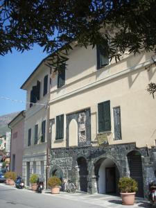 a large stone building with green shutters on a street at Ospitalia del Mare Hostel in Levanto