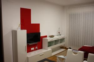 un soggiorno con TV e parete rossa di Sea and Light a Isla Cristina