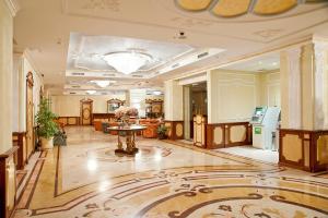 een lobby met een tafel in het midden van een gebouw bij Rimar Hotel Бассейн и СПА in Krasnodar