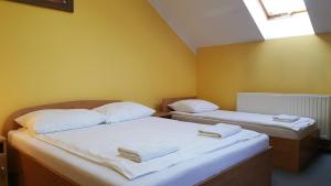 2 camas en una habitación con paredes amarillas en Zajazd Gosciniec en Łańcut