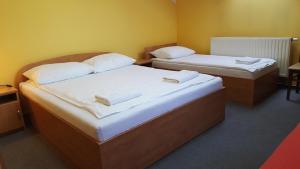 2 camas individuales en una habitación con paredes amarillas en Zajazd Gosciniec, en Łańcut