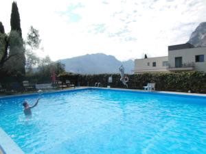 une personne jouant dans une grande piscine dans l'établissement Residence Cascata Varone, à Riva del Garda