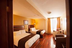 Un pat sau paturi într-o cameră la Hotel Mabey Urubamba