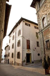 un grand bâtiment blanc sur le côté d'une rue dans l'établissement Hotel Borgo Antico, à Bibbiena