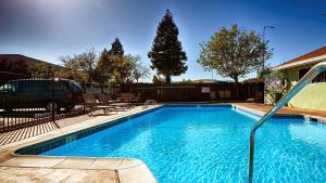 a large blue swimming pool in front of a house at Best Western Heritage Inn in Vacaville