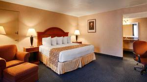 a hotel room with a large bed and a chair at Hotel Pentagon in Arlington