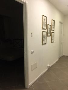 un couloir avec des photos sur un mur blanc dans l'établissement B&B Piazza Dante Nuoro, à Nuoro