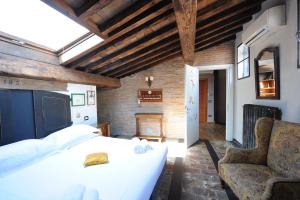 ein Schlafzimmer mit einem großen weißen Bett und einem Sofa in der Unterkunft Acacia Firenze Apartments Cumino-Cannella-Curry in Florenz