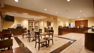 a restaurant with a table and chairs and a bar at Best Western Plus Orchid Hotel & Suites in Roseville