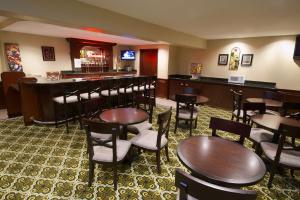 a restaurant with tables and chairs and a bar at Best Western Plus Orchid Hotel & Suites in Roseville