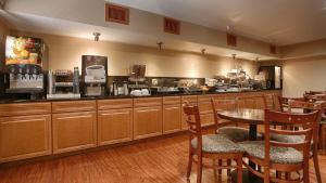 a restaurant with a table and chairs and a kitchen at Best Western Canon City in Canon City