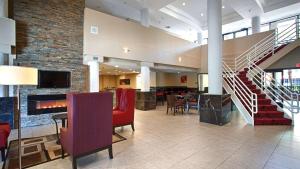 eine Lobby mit einer Treppe sowie Tischen und Stühlen in der Unterkunft Best Western Plus Irvine Spectrum Hotel in Lake Forest