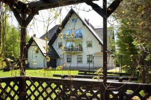a large white house with a fence in front of it at Pensjonat Mijamar in Białogóra