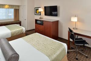 a hotel room with two beds and a desk and a television at Best Western Plus Peak Vista Inn & Suites in Colorado Springs