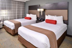 a hotel room with two beds with red pillows at Best Western at O'Hare in Rosemont