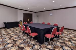 a conference room with a black table and red chairs at Best Western at O'Hare in Rosemont