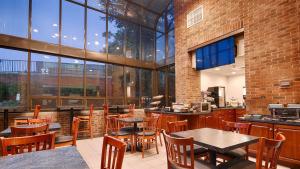 un restaurante con mesas, sillas y ventanas en Best Western Danbury/Bethel en Bethel