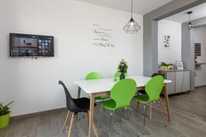 a dining room with a white table and green chairs at Apartment Danijela in Trogir