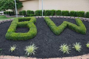 a garden with a bush sign in front of a building at Best Western Richmond Hotel in Richmond
