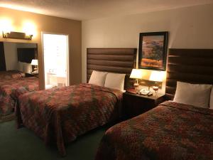 una camera d'albergo con due letti e due lampade di Discovery Inn a Grants Pass