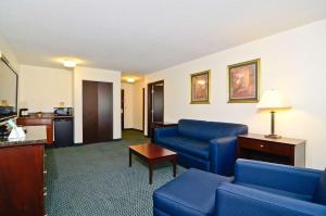 a hotel room with blue chairs and a living room at Best Western Plus Gas City in Gas City