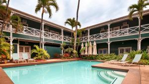a swimming pool in front of a building with palm trees at Best Western Pioneer Inn in Lahaina