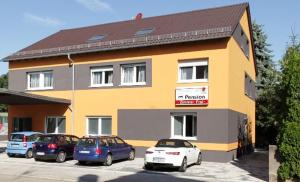 ein gelbes Gebäude mit davor geparkt in der Unterkunft Pension Arkade in Neckarsulm