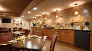 restauracja ze stołem i krzesłami oraz kuchnia w obiekcie Best Western Coach House w mieście Springfield