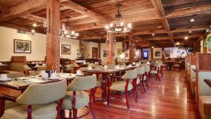 un restaurante con techos de madera, mesas y sillas en Best Western Plus Waterville Grand Hotel, en Waterville