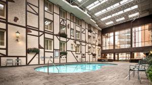 Best Western Plus The Normandy Inn & Suites في مينيابوليس: مبنى كبير مع مسبح في ساحة