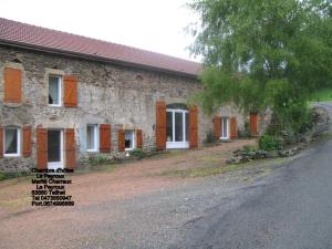 a stone building with orange shutters on the side of it at Le Peyroux in Teilhet
