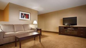 a living room with a couch and a flat screen tv at Best Western Plus York Hotel and Conference Center in York