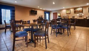 un restaurante con mesas y sillas y una cocina en SureStay Plus Hotel by Best Western Roanoke Rapids I-95, en Roanoke Rapids